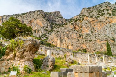 The Stoa of Athenians at the ancient ruin site of Delphi, Greece with mountains in the background clipart