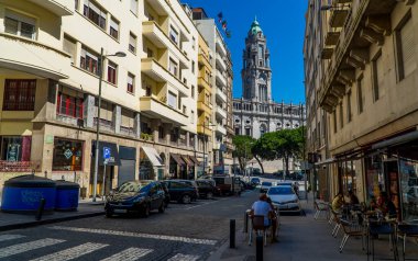 Porto, Portekiz - 3 Eylül 2020 - Teraslı ve arka planda Praca da Liberdade binaları olan bir sokak