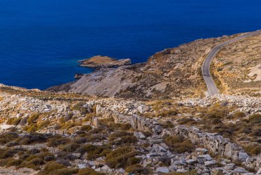 Yunanistan 'ın Tinos, Cyclades adasında Kardiani yakınlarında kıyı yolu olan taşlı manzaralar
