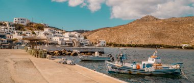 Ormos Panormou (Panormou), Yunanistan - 9 Ekim 2020 - Tinos, Cyclades, Yunanistan 'da balıkçı tekneleri ve Kiklad mimarisi ile Panormos köyünün yatay panoramik görüntüsü