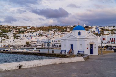 Mykonos Town (Chora), Yunanistan - 19 Ekim 2020 - Mykonos Town Eski Limanı 'ndaki güzel panoramik gezinti alanı ve küçük ortodoks kilisesi, gün batımında Kiklad