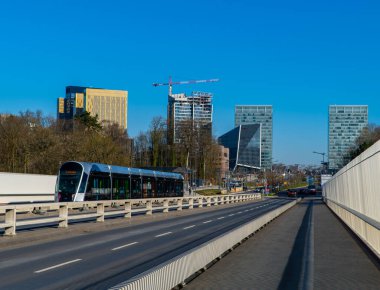 Lüksemburg Şehri, Lüksemburg - 7 Şubat 2020 - İş bölgesindeki modern gökdelenlerin önünden geçen tramvay arabasıyla Kızıl Köprü üzerinde güzel bir öğleden sonra manzarası