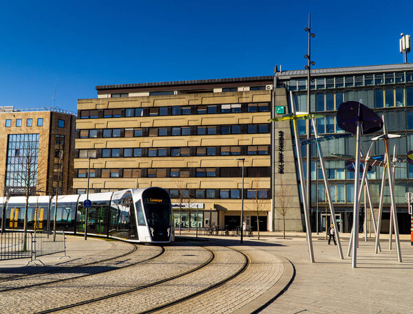 Люксембург, Люксембург - 10 февраля 2020 года - поезд на трамвае, идущий вокруг угла в ясный солнечный день