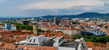 Graz, Avusturya - 16 Haziran 2020 - Castle Hill 'den (Schlossberg) Graz Styria' nın ortaçağ evleri, kiliseleri ve ünlü Kunsthaus - fütürist sanat müzesi - yatay panoramik günbatımı manzarası