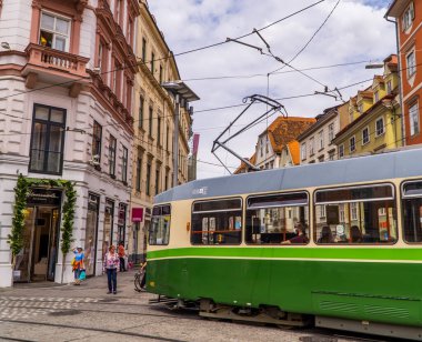Graz, Avusturya - 16 Haziran 2020 - köşeyi dönen klasik tramvay - yüz maskeli yolcular
