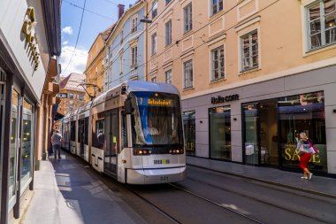Graz, Avusturya - 19 Haziran 2020 - Eski Graz kasabasındaki dükkanların önündeki tramvay treni