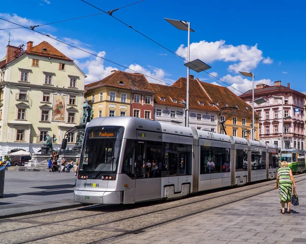 Graz, Avusturya - 19 Haziran 2020 - Modern tramvay treni Hauptplatz 'dan (ana meydan) geçiyor geleneksel Avusturya mimarisinin önünde insanlarla