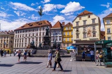 Graz, Avusturya - 19 Haziran 2020 - insanlar Graz 'da Hauptplatz' daki (ana meydan) geleneksel ortaçağ Avusturya evleri ve heykellerinin önünde yürüyorlar.