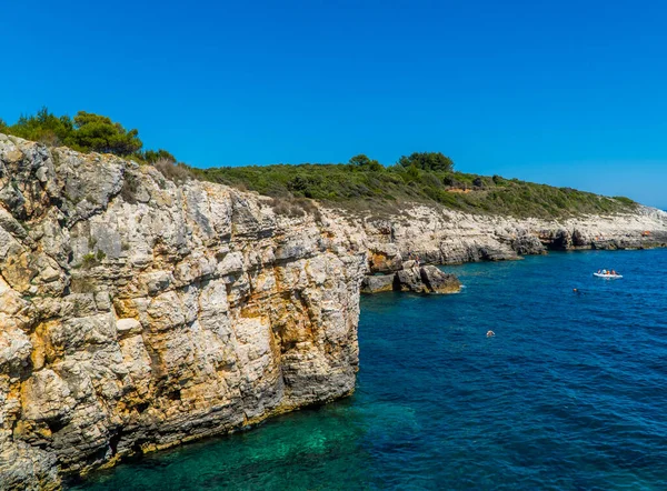 克罗地亚伊斯特拉Kamenjak国家公园美丽的岩石悬崖 船上有许多人 — 图库照片