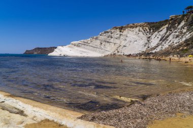 Realmonte, Sicilya yakınlarındaki Scala dei Turchi 'de (Türklerin Merdiveni) sahili ve yüzücüleri olan kireçtaşı beyaz uçurumlar