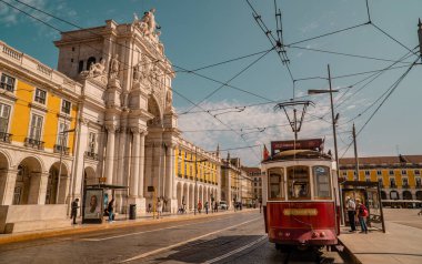 Lizbon, Portekiz - 21 Eylül 2020 - Zafer kemerli Praca do Comercio 'daki klasik hafif tren günbatımı manzarası