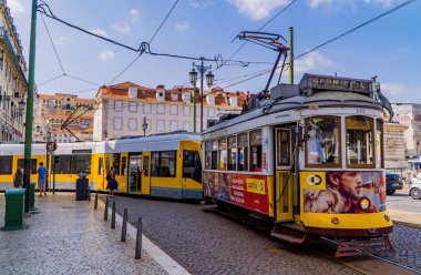 Lizbon, Portekiz - 21 Eylül 2020 - Geleneksel mimari ve klasik tramvay treni Praca da Figueira 'daki yeni tramvayın önünde