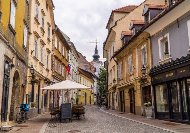 Ljubljana, Slovenya - 26 Haziran 2020 - Eski kentte geleneksel evleri, terasları ve otelleri olan bir cadde