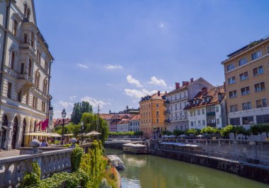 Ljubljana, Slovenya - 26 Haziran 2020 - Geleneksel evleri ve turist tekneleriyle Ljubljanica nehri