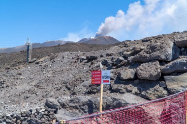 Etna Dağı, İtalya - 25 Temmuz 2020 - Etna Dağı 'nda yürüyüş yapanlar sigara içiyorlar ve arka planda küller var