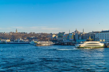 İstanbul, Türkiye - 2 Şubat 2021 - Eminonu 'daki feribotlu rıhtımların panoramik manzarası ve arka plandaki tepenin üzerindeki Ayasofya Büyük Camii