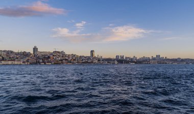 İstanbul, Türkiye - 9 Şubat 2021 - İstanbul 'un Avrupa yakasının gökdelenli İstanbul Boğazı' ndan gündoğumu manzarası