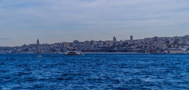 İstanbul, Türkiye - 9 Şubat 2021 - Avrupa tarafında Galata ve Karaköy 'ün ufuk çizgisi önünde bir feribot İstanbul Boğazı' ndan görüldü