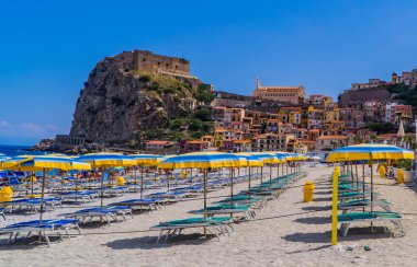 Scilla, İtalya - 22 Temmuz 2020 - Şemsiyeler Scilla, Calabria 'nın güzel sahillerinde kaya ve tepede Ruffo Kalesi