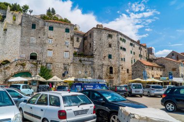 Sibenik, Hırvatistan - 4 Temmuz 2020 - Dalmaçya 'nın Sibenik kentindeki tepedeki ortaçağ evlerinin önünde arabalarla park