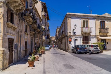 Syracusa, İtalya - 26 Temmuz 2020 - Geleneksel mimari ve arabalarla dolu bir meydan