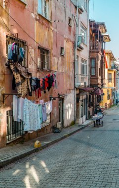 Balat, İstanbul, Türkiye - 23 Şubat 2021 - Balat, İstanbul 'da giysileri asılmış köhne evlerin sokak fotoğrafları