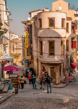 Balat, İstanbul, Türkiye - 23 Şubat 2021 - Turistlerin Balat mahallesindeki tipik evlerle fotoğraf çektiği sokak manzarası