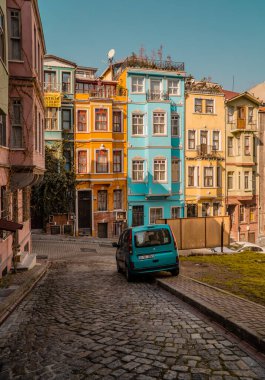 Balat, İstanbul, Türkiye - 23 Şubat 2021 - geleneksel renkli evlere sahip tarihi Balat bölgesinde ünlü bir caddede araba