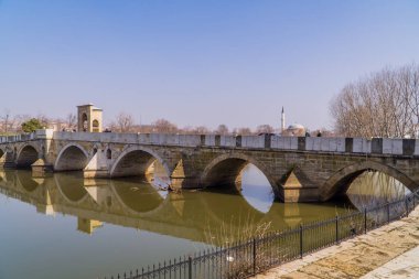 Edirne, Türkiye - 26 Şubat 2021 - Meric Nehri üzerinde Meriç Köprüsü ve arka planda küçük bir cami