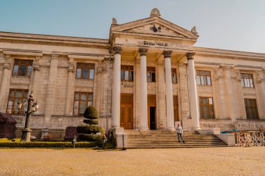 İstanbul, Türkiye - 23 Şubat 2021 - Sultanahmet 'teki ünlü İstanbul Arkeoloji Müzesi' nin gün batımında bir turistle sokak manzarası