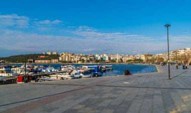 Çanakkale, Türkiye - 1 Mart 2021 - Canakkale limanında teknelerle oturan bir çiftin panoramik sokak görüntüsü