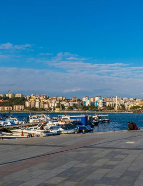 Çanakkale, Türkiye - 1 Mart 2021 - Teknelerle Çanakkale limanında oturan bir çiftin dikey sokak fotoğrafı