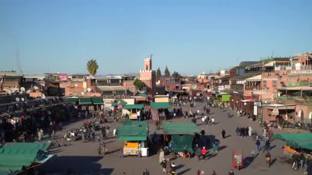 Marrakech, Marruecos - 14 de enero de 2021 - Timelapse of the famous Jemaa el Fnaa square with people, shops, orange juice stalls, and mosque with a minaret — Vídeos de Stock