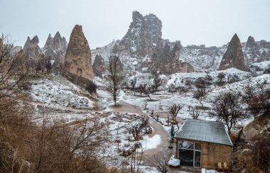 Türkiye 'nin Kapadokya kentinde kar içindeki peri bacaları ve kaya oluşumları