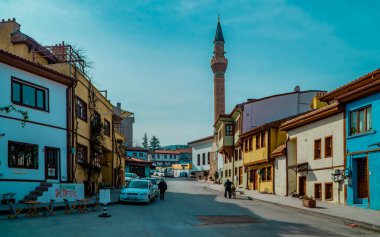 Eskisehir, Türkiye - 8 Mart 2021 - Odunpazari Mahallesi 'nde bir kafe ve küçük bir cami ile geleneksel Osmanlı binalarının sokak fotoğrafları