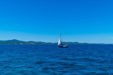 Zadar, Croatia - July 11, 2020 - sailing boat close to the coast in Zadar, Dalmatia with mountains in the background