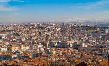 Ankara, Türkiye - 12 Mart 2021 - Ankara Kalesi 'nin arka planında binalar ve karla kaplı dağlarla Ankara, Türkiye şehir merkezinin panoramik görüntüsü)