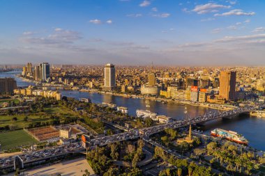 Kahire, Mısır - 25 Mart 2021 - Kahire Kulesi 'nin manzarası ve tekneleri ile Nil ve şehir merkezinin panoramik hava günbatımı görüntüsü
