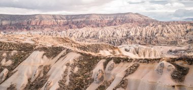 Türkiye 'nin Goreme kenti yakınlarındaki kaya oluşumları ve peri bacalarıyla eşsiz Kapadokya manzaralarının güzel yatay karamsar manzarası