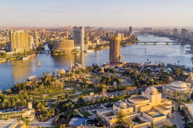 Kahire, Mısır - 25 Mart 2021 - Kahire Operası, otelleri ve Kahire siluetinin arka planda yer aldığı Nil Nehri 'nin muhteşem panoramik manzarası gün batımında