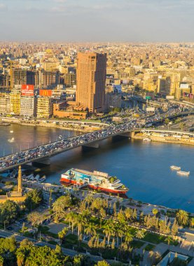 Kahire, Mısır - 25 Mart 2021 - Kahire Kulesi 'nin manzarası ve tekneleri ile Nil ve şehir merkezinin güzel dikey hava günbatımı manzarası