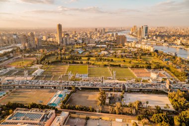 Kahire, Mısır - 25 Mart 2021 - Zamalek ve Kahire 'nin arka planında günbatımında ufuk çizgisi olan 6 Ekim Köprüsü' nde otoyol