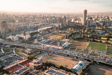 Kahire, Mısır - 25 Mart 2021 - Zamalek ve Kahire 'nin arka planında günbatımında ufuk çizgisi olan 6 Ekim Köprüsü' nde otoyol
