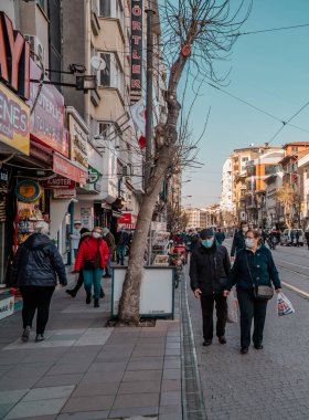 Eskisehir, Türkiye - 8 Mart 2021 - Eskisehir şehir merkezindeki insan ve dükkanların dikey sokak fotoğrafı