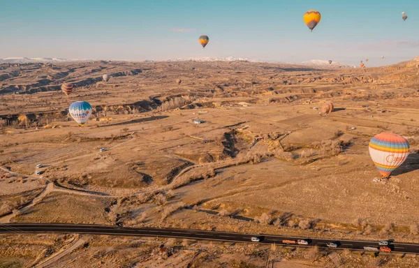 ゴーム カッパドキア トルコ 2021年3月19日 熱気球飛行と壮大な岩の形成を持つカッパドキアの道路上を走行する車の空中ビュー — ストック写真