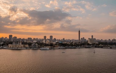 Kahire, Mısır - 25 Mart 2021 - Nil Nehri 'nin günbatımı manzaralı tekneleri, Kahire Kulesi ve Zamalek' teki oteller