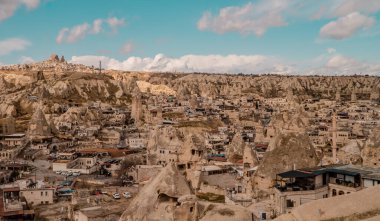 Goreme, Türkiye - 20 Mart 2021 - Türkiye 'nin Kapadokya kentindeki Goreme kentinin peri bacaları, evleri ve eşsiz kaya oluşumları ile panorama görüntüsü