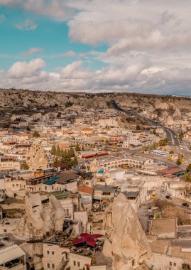 Goreme, Türkiye - 20 Mart 2021 - Türkiye 'nin Kapadokya kentindeki Goreme kentinin merkezi dikey görünümü, peri bacaları, evleri ve benzersiz kaya oluşumları