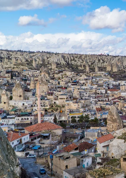 Goreme, Türkiye - 20 Mart 2021 - Türkiye 'nin Kapadokya kentindeki Goreme kentinin merkezi dikey görünümü, peri bacaları, evleri, arabaları ve benzersiz kaya oluşumları
