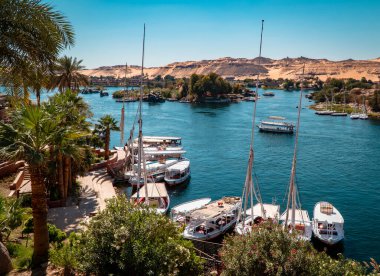 Aswan, Mısır - 2 Nisan 2021 - Arka planda fil adası olan Eski Katarakt Oteli 'nden görülen teknelerin görüntüsü